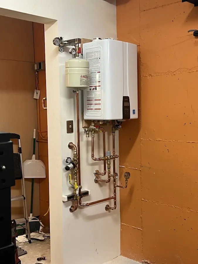 Plumbing technician inspecting water heater connections in South Sioux City